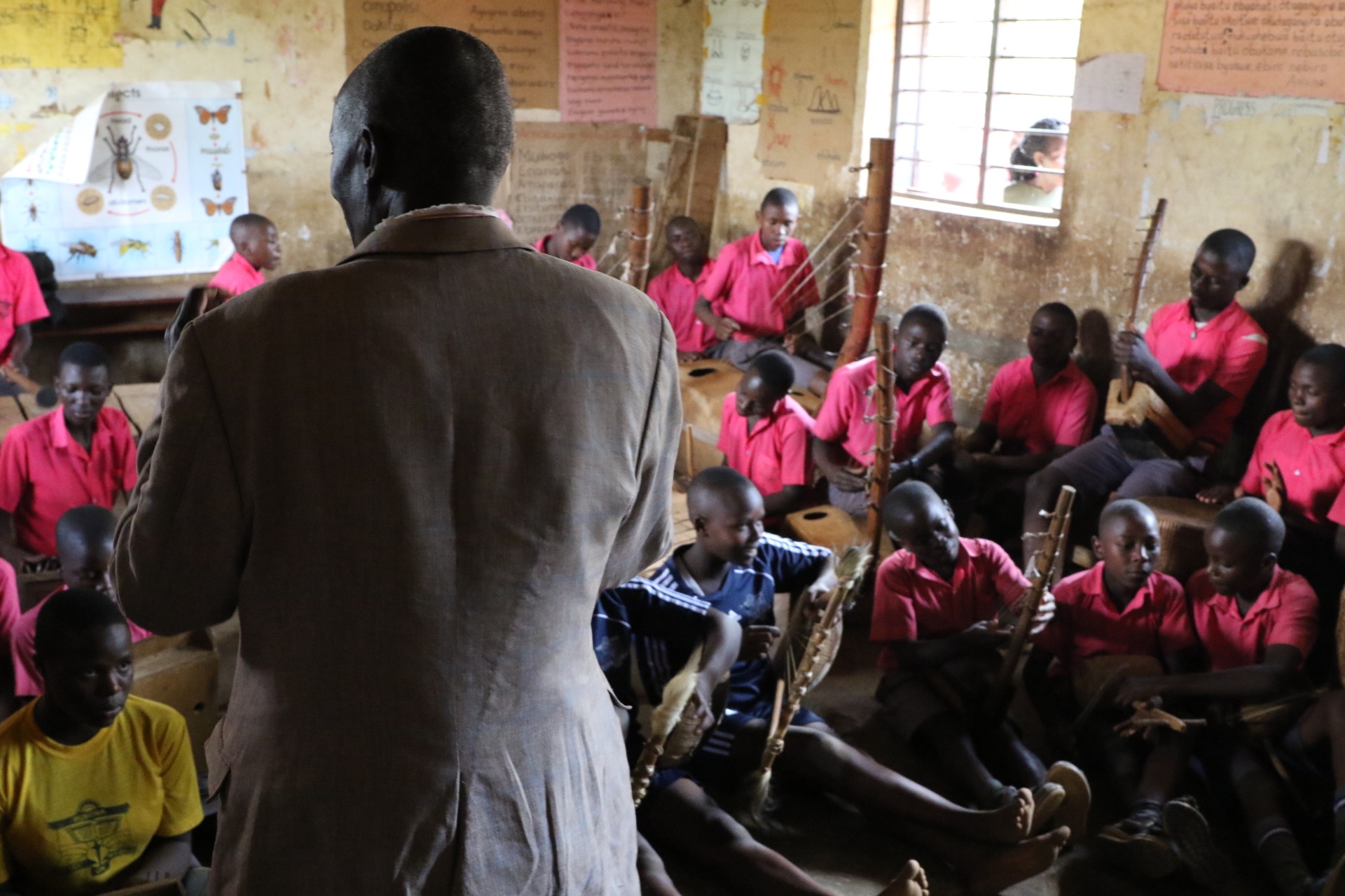 A teacher leading a music and instrument lesson with students.